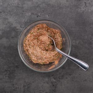 A bowl with French Fry Seasoning with a spoon.