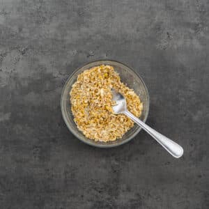 A bowl of lemon pepper seasoning with a spoon.