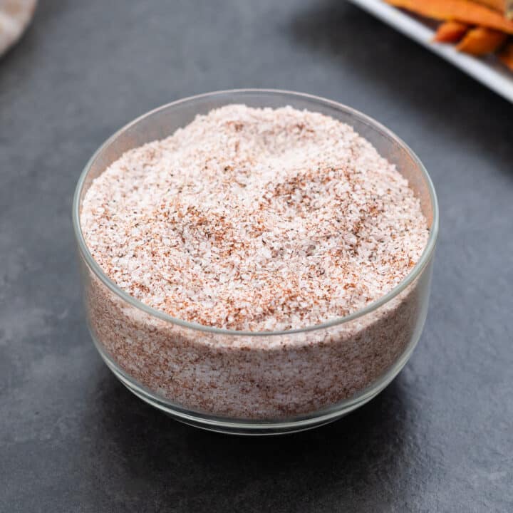 Homemade seasoned salt served in a clear glass bowl, showcasing its texture and color.