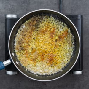 Spices and turmeric blooming in a pan with oil butter mix.