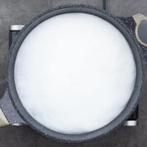 A pot with water milk mixture on the stove.