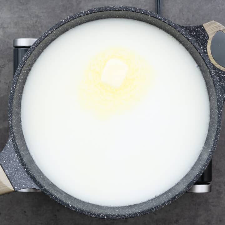 A pot containing a mixture of milk and butter is being warmed.