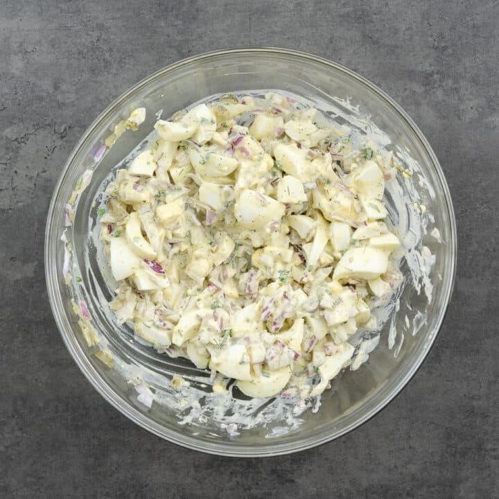 A glass bowl with creamy egg salad.