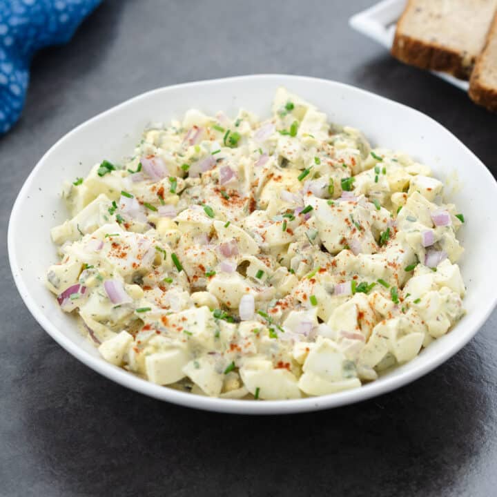 Creamy egg salad served in a white bowl.