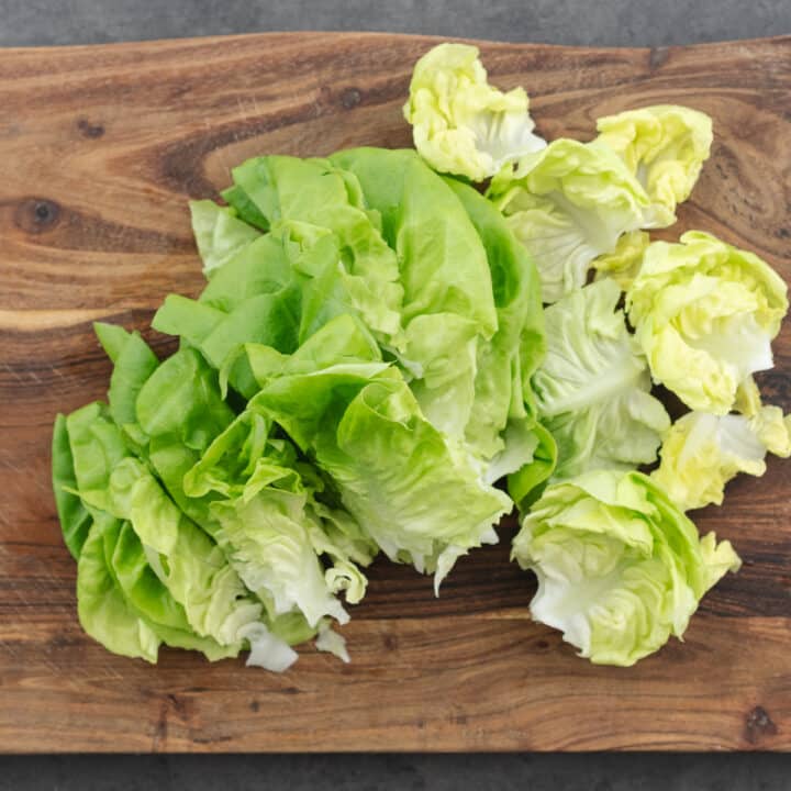 Wooden board with chopped butter lettuce.