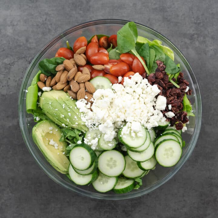 Bowl of assembled green salad ingredients.