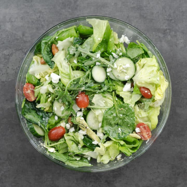 Bowl of green salad tossed in lemon vinaigrette.