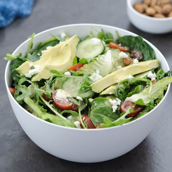 Green salad served in a white bowl.