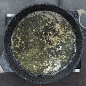 Chicken broth and lemon juice mixture boiling in a pan.