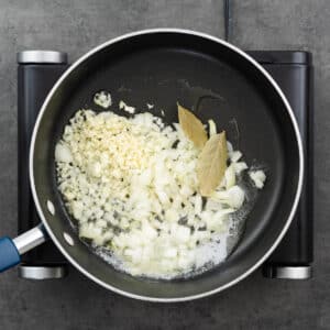A pan with aromatics and bay leaves.