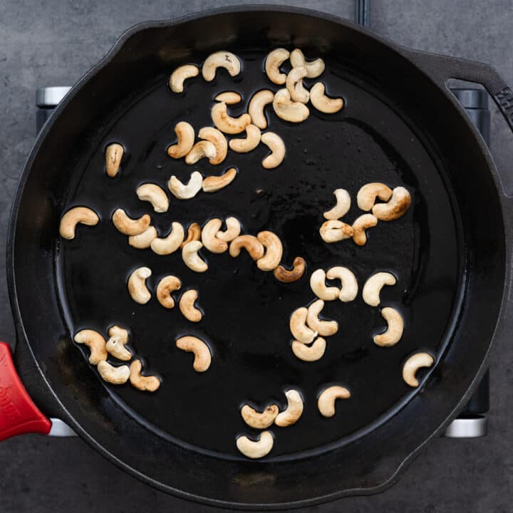 A cast iron pan with golden brown toasted cashews.