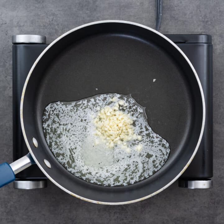 A pan with melted butter and minced garlic sizzling together.