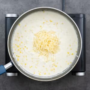 A pan with the creamy corn mixture, with Parmesan cheese.