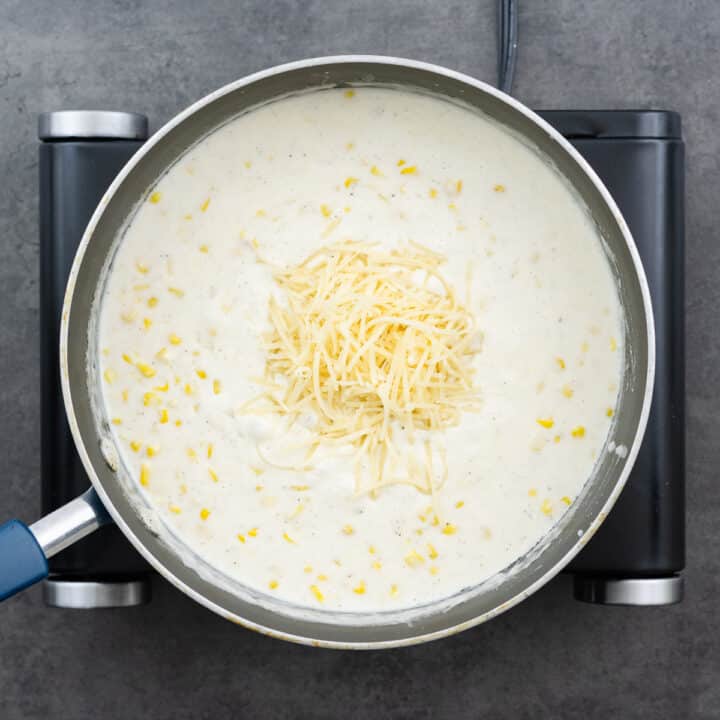 A pan with the creamy corn mixture, with Parmesan cheese.