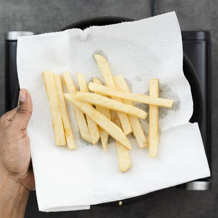 Double-fried crispy chips on a paper towel-lined tray.