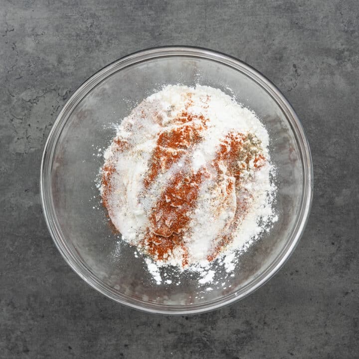 A bowl with flour and baking powder for making batter.