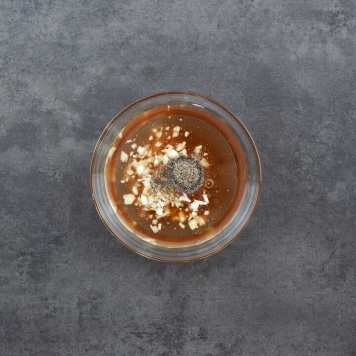 A bowl filled with salad dressing ingredients, ready to be mixed.