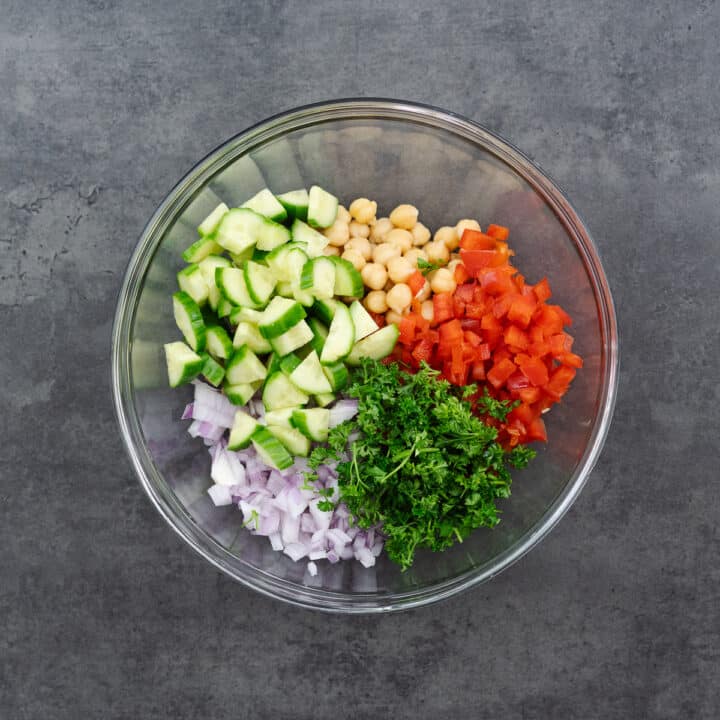 A bowl containing cooked chickpeas and crisp vegetables.