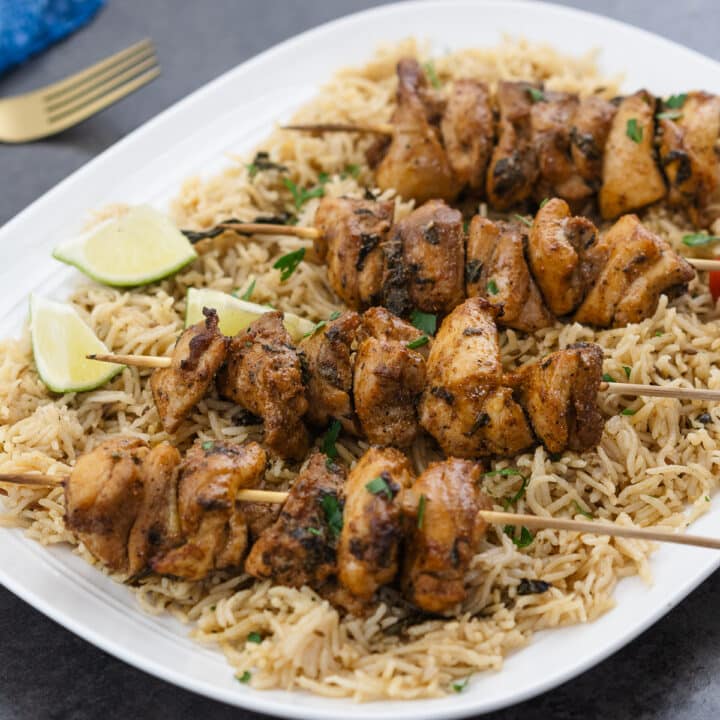 Baked chicken skewers served on top of rice pilaf.