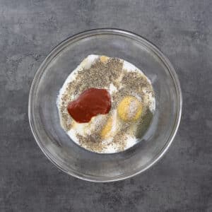 A bowl with marination ingredients for chicken.
