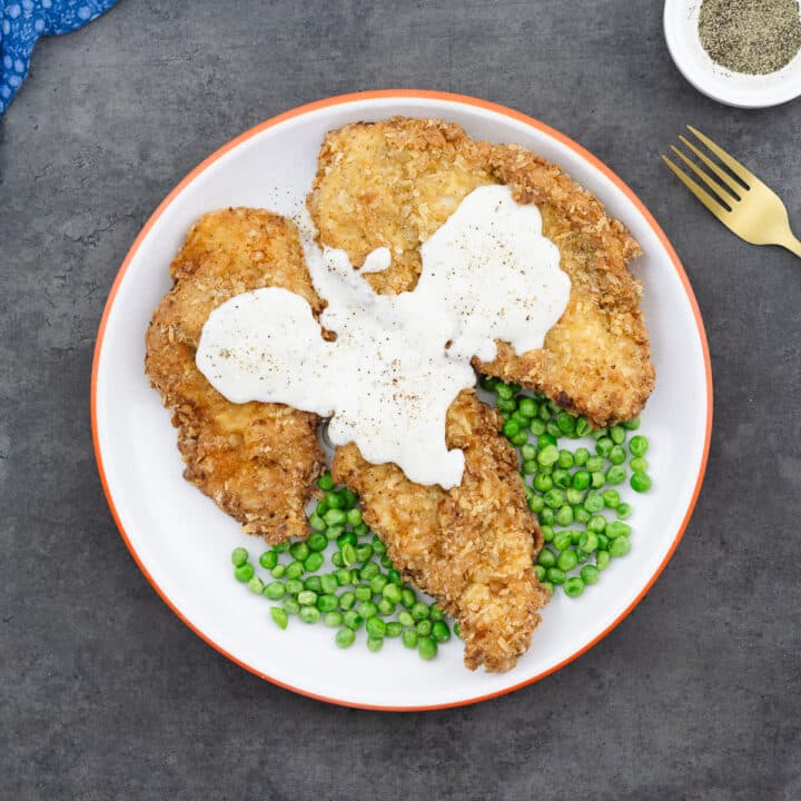 Chicken Fried Chicken served with white gravy and steamed green peas.