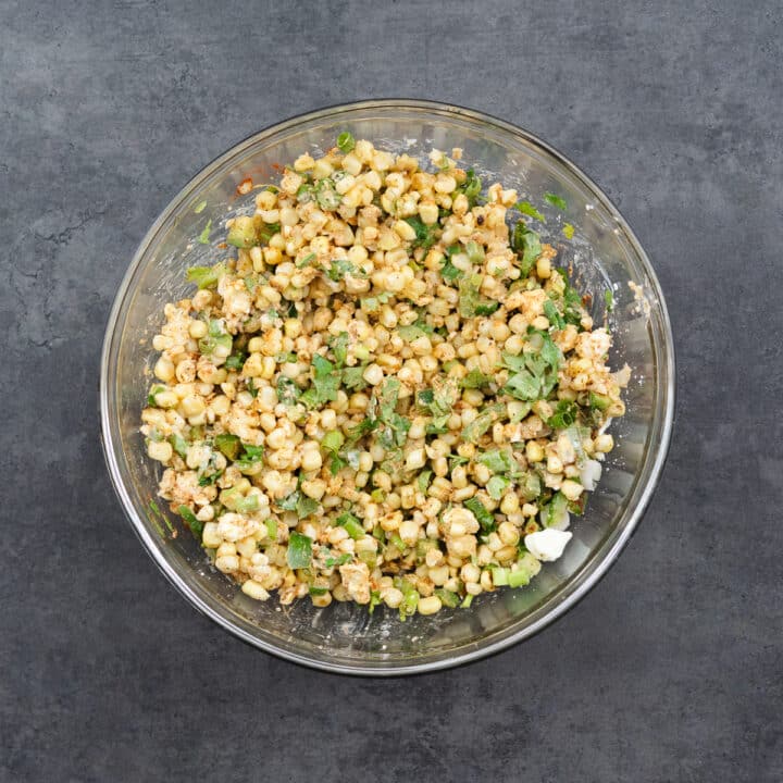 A bowl of vibrant Mexican Street Corn Salad, packed with grilled corn, spices, and fresh herbs.