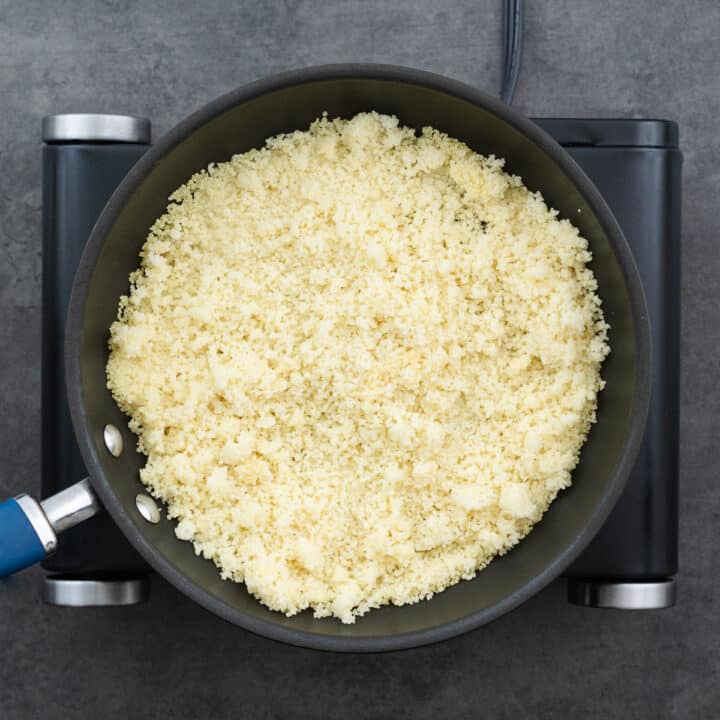 A saucepan with fluffy, cooked couscous ready for mixing.