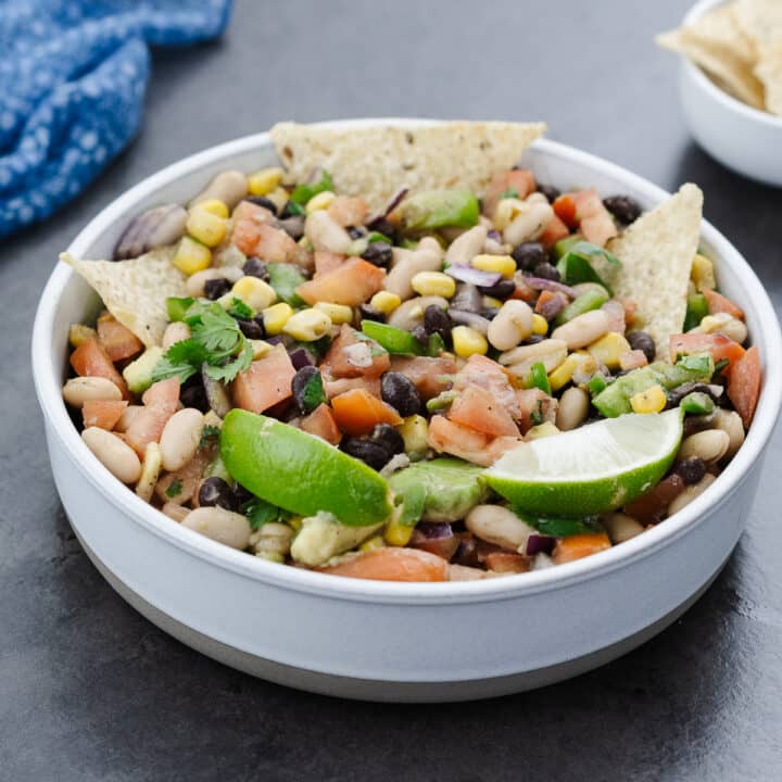 A white bowl filled with vibrant Cowboy Caviar salad, garnished and ready to enjoy.