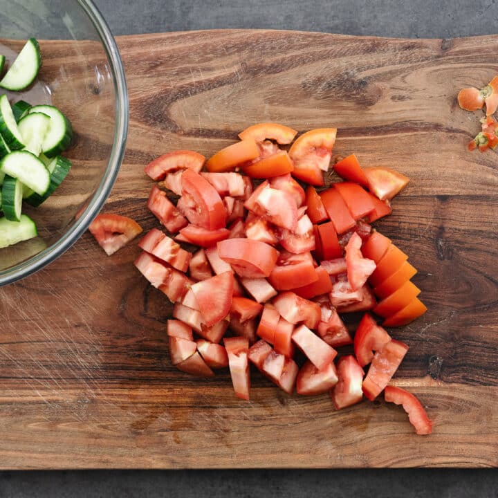 A cutting board with diced tomatoes.