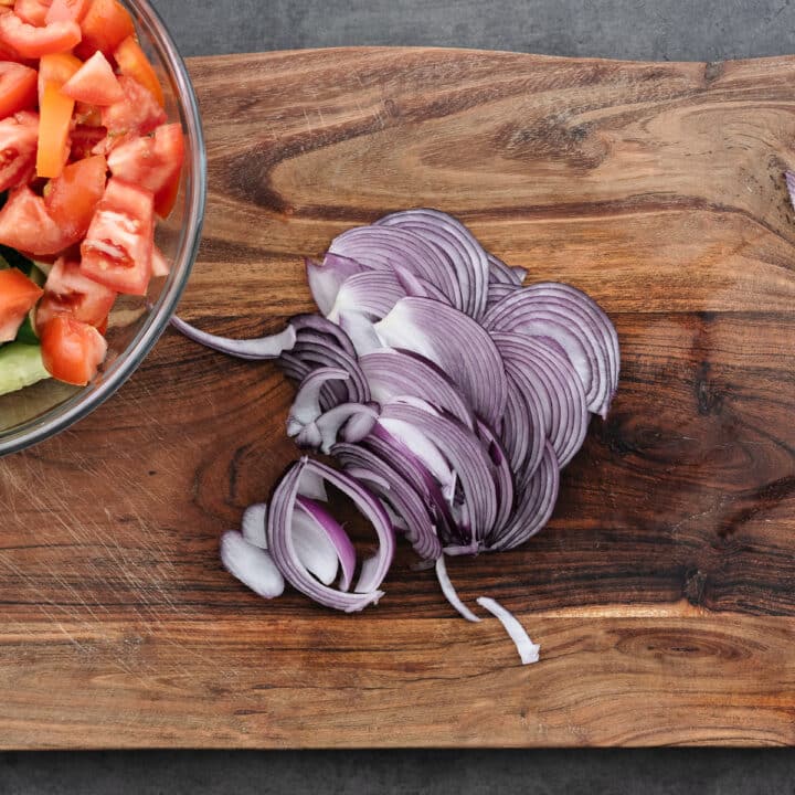 A cutting board with chopped onions.