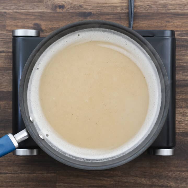 A pan with the gravy mixture simmering on low heat.