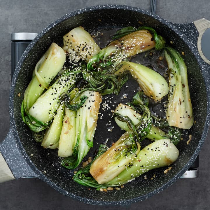 Sautéed bok choy garnished with sesame seeds, adding a nutty crunch.