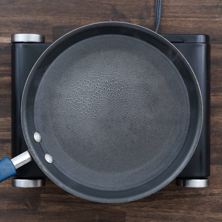 A close-up of a pan filled with boiling water over medium heat.