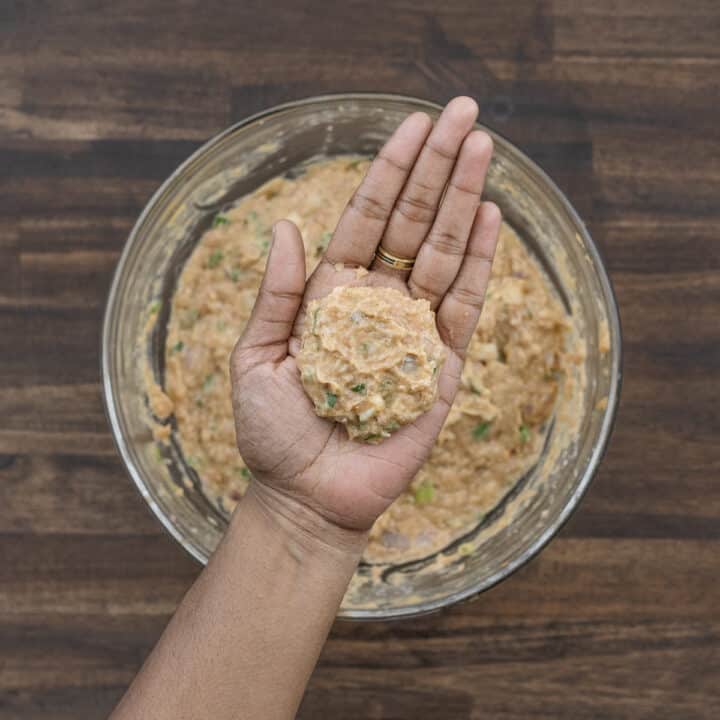 Ground chicken mixture shaped into patties, displayed on a palm, ready for cooking.