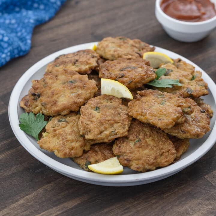 Chicken patties served on a white plate with lemon wedges, ready to enjoy.