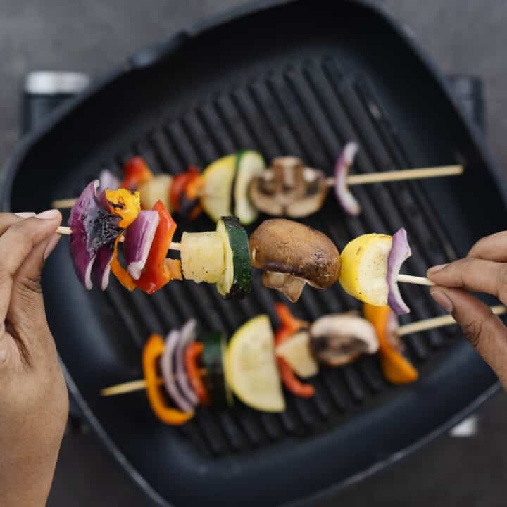 A close-up image highlighting the texture of grilled vegetable skewers, showing their smoky appearance.