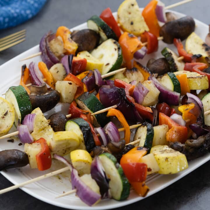 Vegetable skewers served on a white plate, presenting a colorful and appetizing meal.