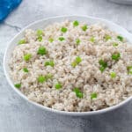 Home-cooked barley in a white bowl on a white table.