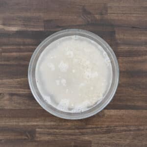 A bowl filled with barley and water, ready for rinsing.