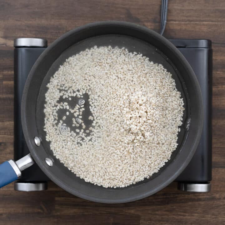 A pan with barley and water, ready for cooking.