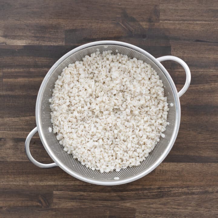 Cooked tender barley rinsed in a colander.