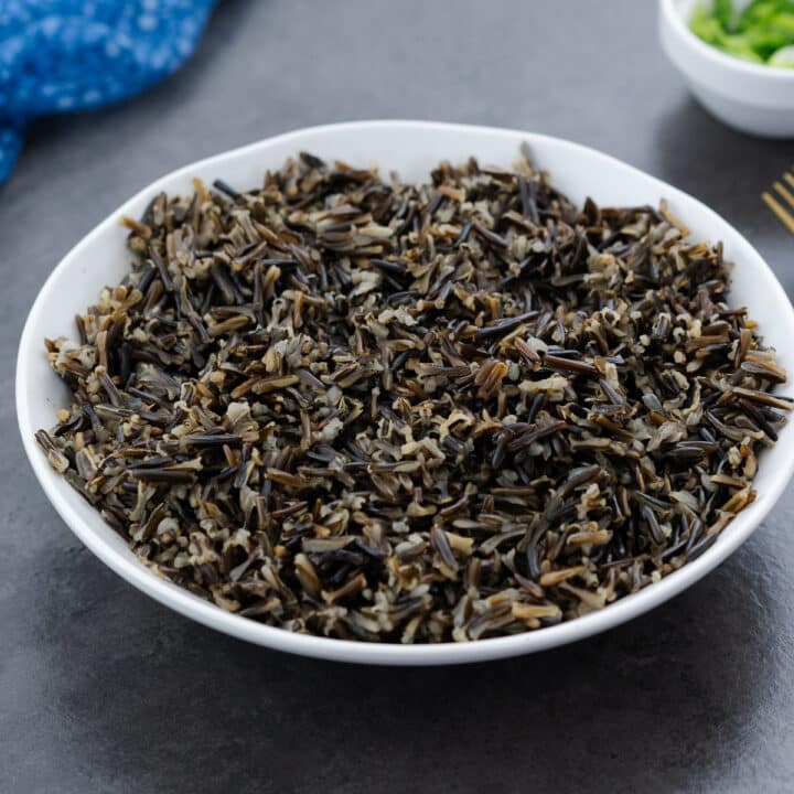 Cooked wild rice served in a white bowl, ready to eat.