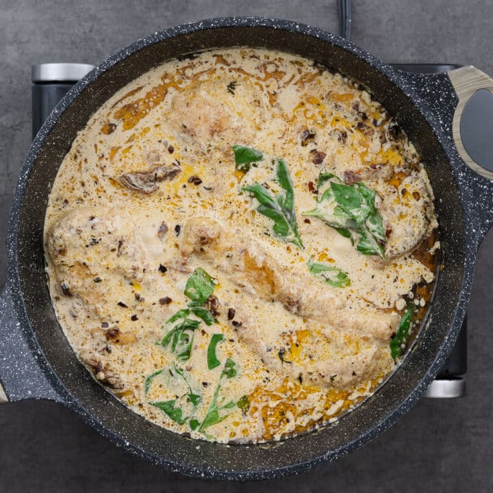 Marry Me Chicken garnished with fresh basil leaves in a pan, ready to serve.