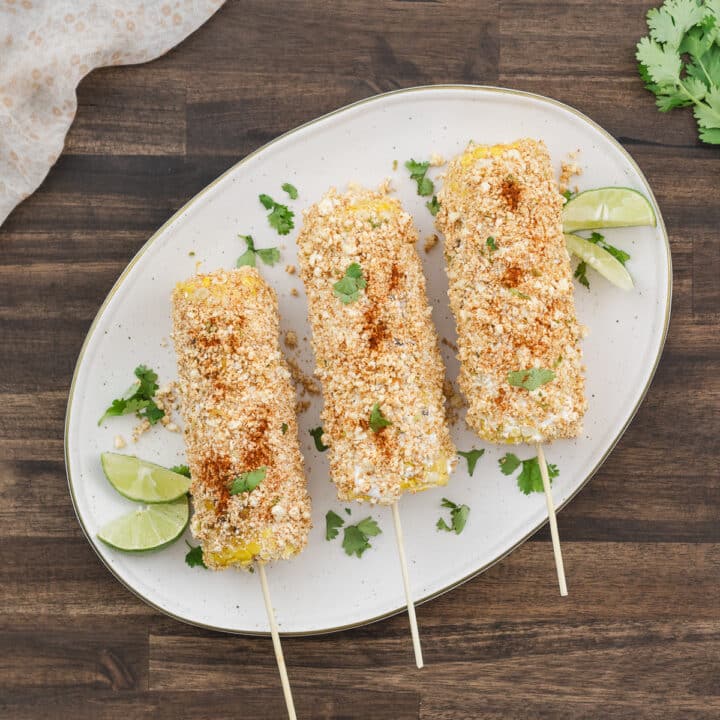 Mexican Street Corn (Elote) served on a white plate, ready to enjoy.