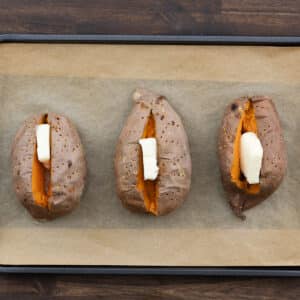 Baked sweet potatoes topped with a pat of butter.