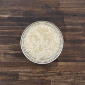 Bowl with rice and water, ready for rinsing.