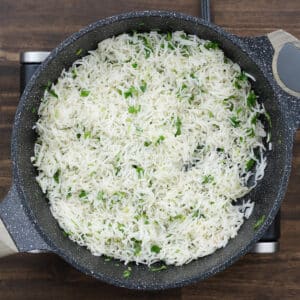 Pan of basmati rice garnished with fresh cilantro, lime zest oil, and lime juice.