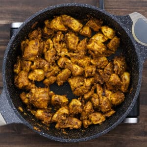 A pan with tender boneless chicken pieces coated in a flavorful spice mixture.