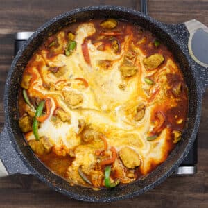 A pan with chicken and veggies with creamy coconut milk added for a rich texture.