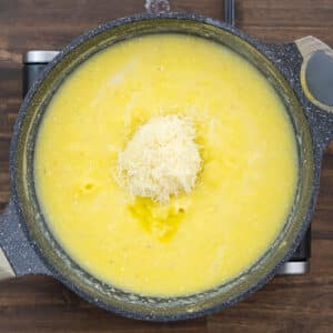A pan with cooked polenta and Parmesan cheese.
